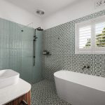 Modern bathroom design featuring a freestanding bathtub, patterned tile flooring, and a walk-in shower with glass enclosure, showcasing a blend of functionality and aesthetic appeal for home renovations.