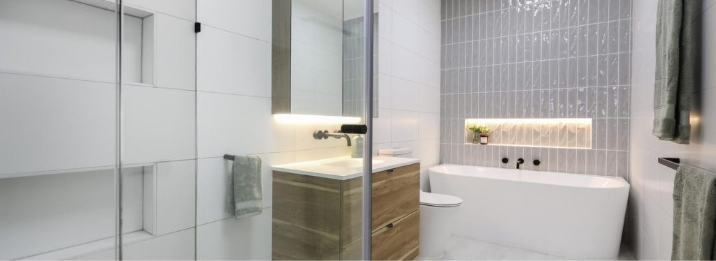 Modern bathroom design featuring a freestanding bathtub, sleek vanity with wooden accents, and contemporary tile work, illustrating high-quality finishes for home renovations.